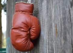 brown boxing glove hanging from wooden wall