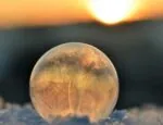 frozen ice bubble in snow against sunset