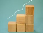 upward white arrow line stretching across vertically-stacked wooden block pieces