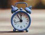 blue alarm clock with dial hands