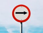 black arrow on white and red traffic sign