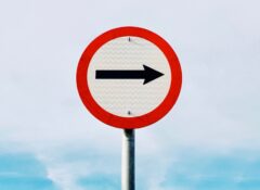 black arrow on white and red traffic sign