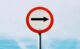 black arrow on white and red traffic sign